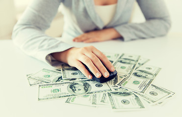 Image showing close up of hand with computer mouse on money