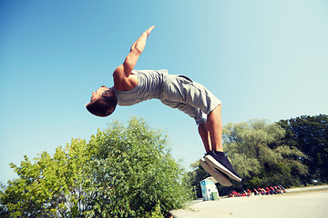 Image showing sporty young man jumping in summer park