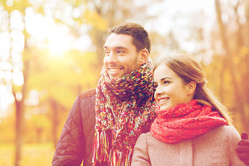 Image showing smiling couple hugging on bridge in autumn park