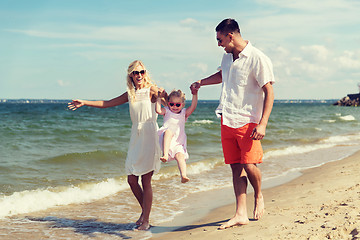 Image showing happy family in sunglasses walking on summer beach