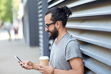 Image showing man with coffee texting on smartphone in city