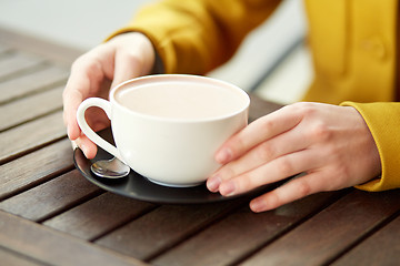 Image showing close up of woman with cocoa cup at street cafe