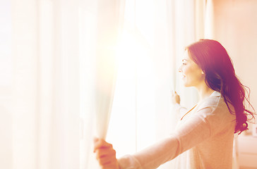 Image showing close up of woman opening window curtains