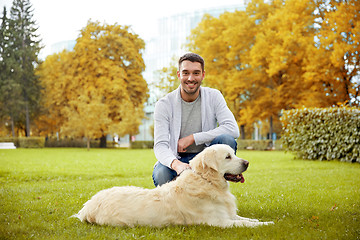 Image showing happy man with labrador dog in autumn city park