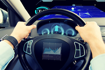 Image showing close up of man driving car with graph on screen