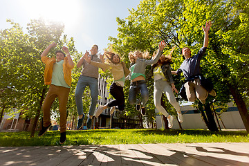 Image showing happy teenage students or friends jumping outdoors