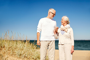 Image showing happy senior couple talking on summer beach