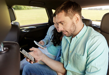 Image showing man and woman with smartphones driving in car