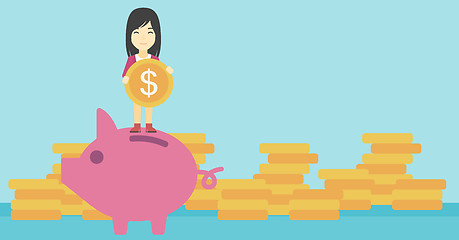 Image showing Business woman putting coin in piggy bank.