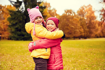 Image showing two happy little girls hugging in autumn park