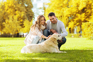 Image showing happy couple with labrador dog in autumn city park