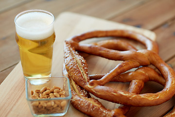 Image showing close up of beer, pretzels and peanuts on table