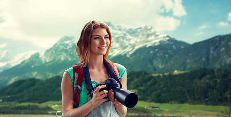 Image showing woman with backpack and camera over mountains