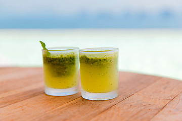 Image showing glasses of fresh juice or cocktail on beach