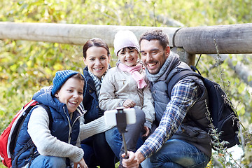 Image showing happy family with smartphone selfie stick in woods