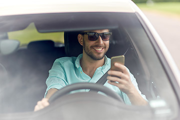 Image showing happy man in shades driving car with smartphone