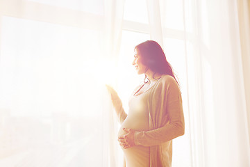 Image showing close up of happy pregnant woman looking to window