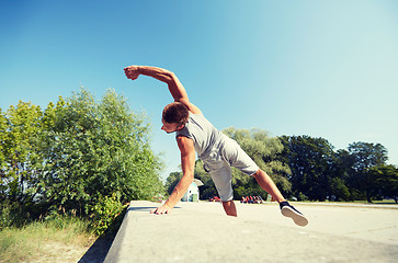 Image showing sporty young man jumping in summer park