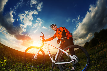 Image showing wide angle portrait against blue sky of mountain biker Cyclist