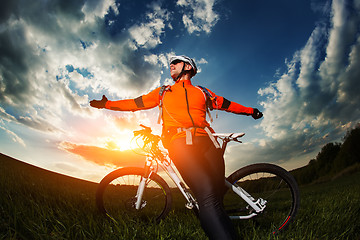 Image showing wide angle portrait against blue sky of mountain biker Cyclist