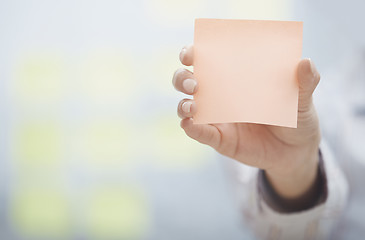 Image showing Hand of woman holding sticky note with empty space