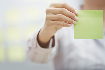 Image showing Hand of woman holding sticky note with empty space