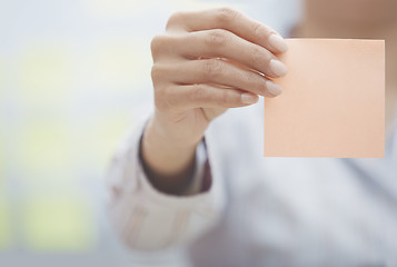 Image showing Hand of woman holding sticky note with empty space