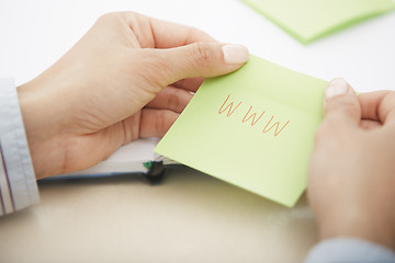 Image showing Hands holding sticky note with internet address