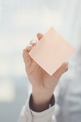 Image showing Hand of woman holding sticky note with empty space