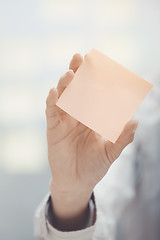 Image showing Hand of woman holding sticky note with empty space