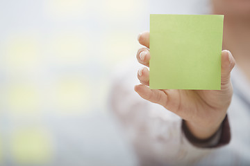 Image showing Hand of woman holding sticky note with empty space