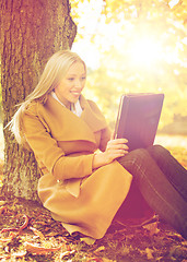 Image showing woman with tablet pc in autumn park