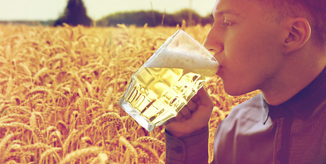 Image showing close up of young man drinking beer from glass mug