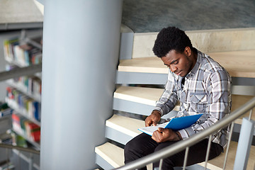 Image showing african student boy or man reading book at library