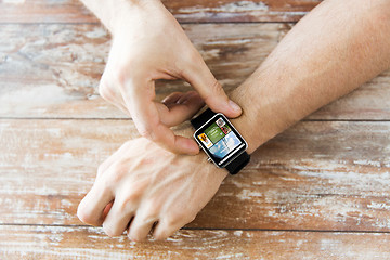 Image showing close up of male hands setting smart watch