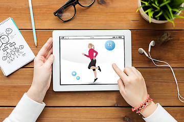 Image showing close up of woman with fitness app on tablet pc