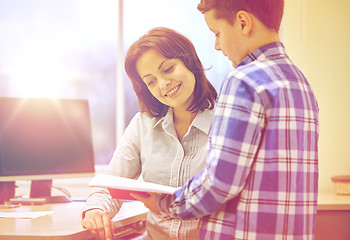 Image showing school boy with notebook and teacher in classroom