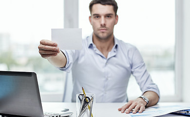 Image showing businessman showing blank paper card at office