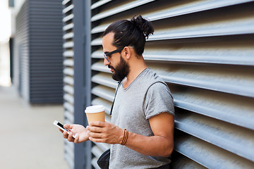 Image showing man with coffee texting on smartphone in city