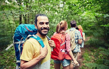 Image showing group of smiling friends with backpacks hiking