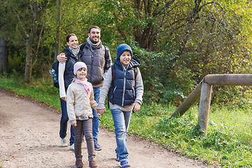 Image showing happy family with backpacks hiking in woods