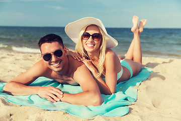 Image showing happy couple in swimwear lying on summer beach