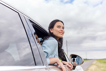 Image showing happy young woman driving in car