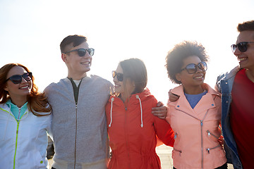 Image showing happy teenage friends in shades talking on street