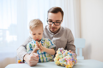 Image showing father and son playing with ball clay at home