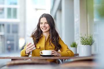 Image showing happy woman texting on smartphone at city cafe