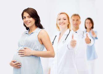 Image showing happy pregnant woman touching her big belly