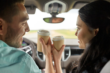Image showing happy man and woman driving in car with coffee