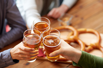 Image showing close up of hands clinking beer at bar or pub