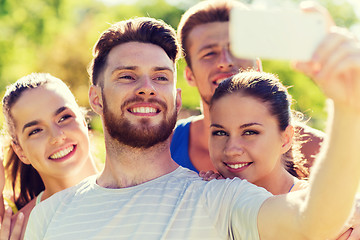 Image showing happy friends taking selfie with smartphone